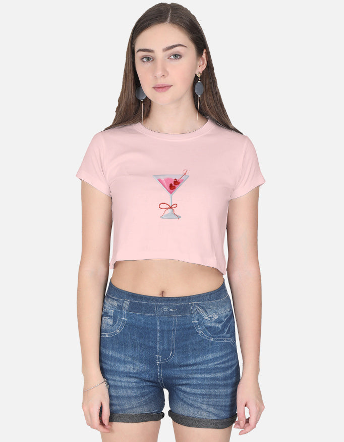 Model wearing light pink cotton crop top with pink cocktail embroidery – short sleeves, paired with denim shorts