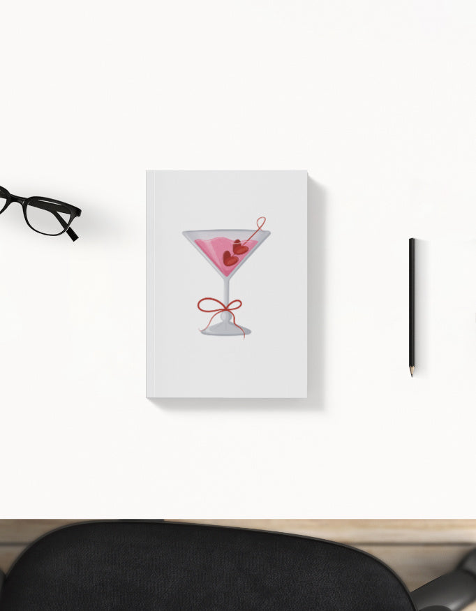 Aesthetic daily planner with pink cocktail glass cover – flat lay with pen and glasses, perfect for organizing tasks and goals